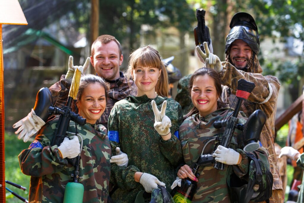 Freunde posieren mit Paintball Waffen im Wald | Paintball Waffen